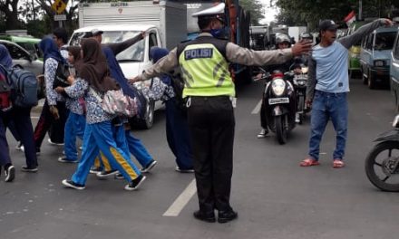 Anggota Lantas Polsek batu ceper membantu gatur lalin menyebrangkan siswa-siswi pelajar sekolah SMP Negeri 7 Batu Ceper Kota Tangerang