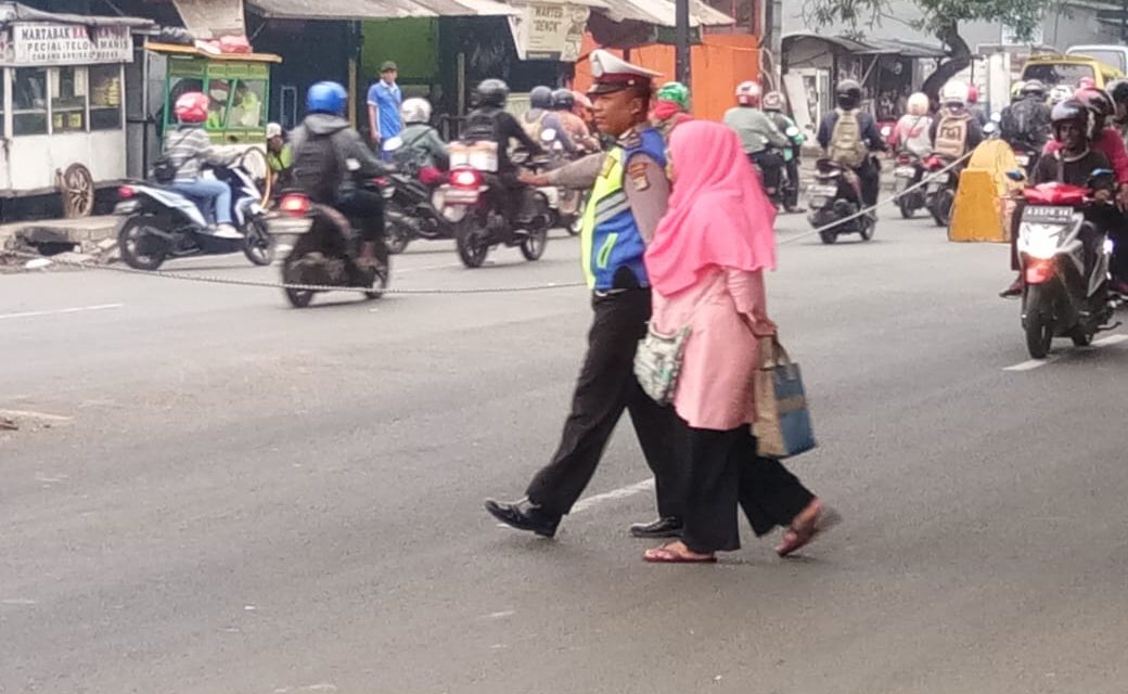 Jaga Keselamatan di Jalan Raya, Anggota Unit Lantas Polsek Jatiuwung Bantu Warga Yang Ingin Menyeberang Jalan