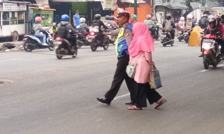 Jaga Keselamatan di Jalan Raya, Anggota Unit Lantas Polsek Jatiuwung Bantu Warga Yang Ingin Menyeberang Jalan