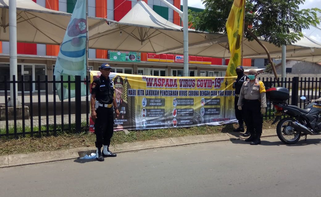 Bhabinkamtibmas Dibantu Security Pasang Spanduk Himbauan Kapolda Metro Jaya Cara Pencegahan Covid-19