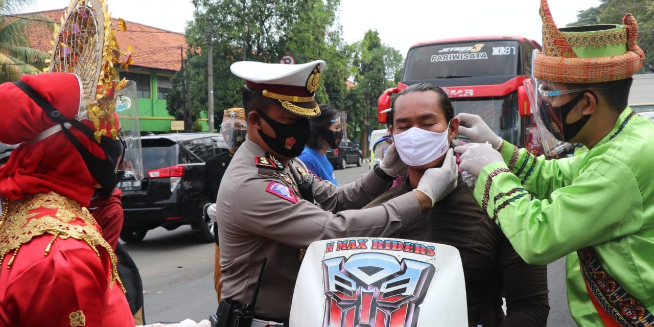 Gunakan Baju Adat di Jalan Raya, Polisi Bagikan Masker Kepada Pengendara