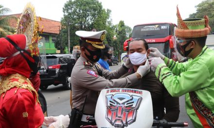 Gunakan Baju Adat di Jalan Raya, Polisi Bagikan Masker Kepada Pengendara