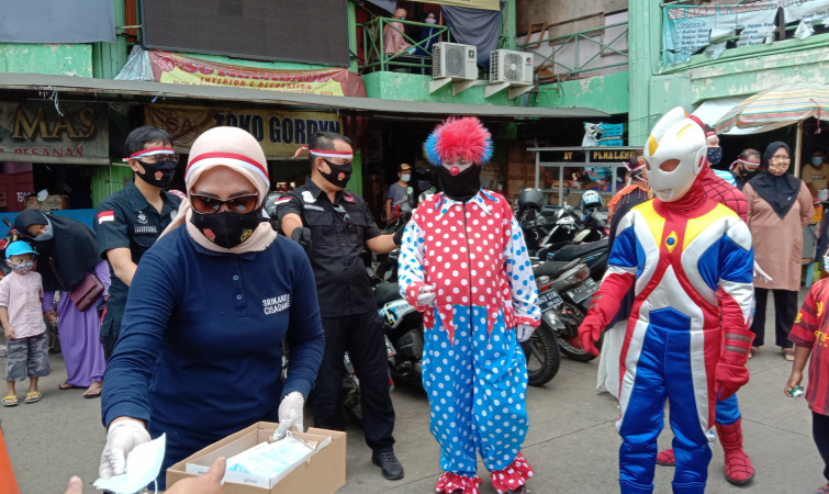 Dengan Berkostum Badut dan Superhero, Polisi Bagikan Masker dan Vitamin C di Pasar Anyar