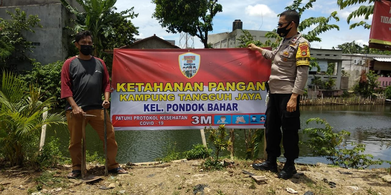 Bhabinkamtibmas Memasang Spanduk Kampung Tangguh Jaya