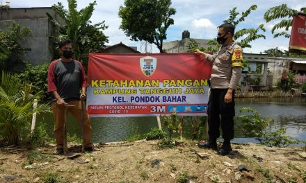 Bhabinkamtibmas Memasang Spanduk Kampung Tangguh Jaya